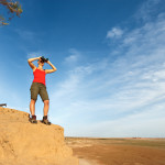 Young woman is looking through a binoculars